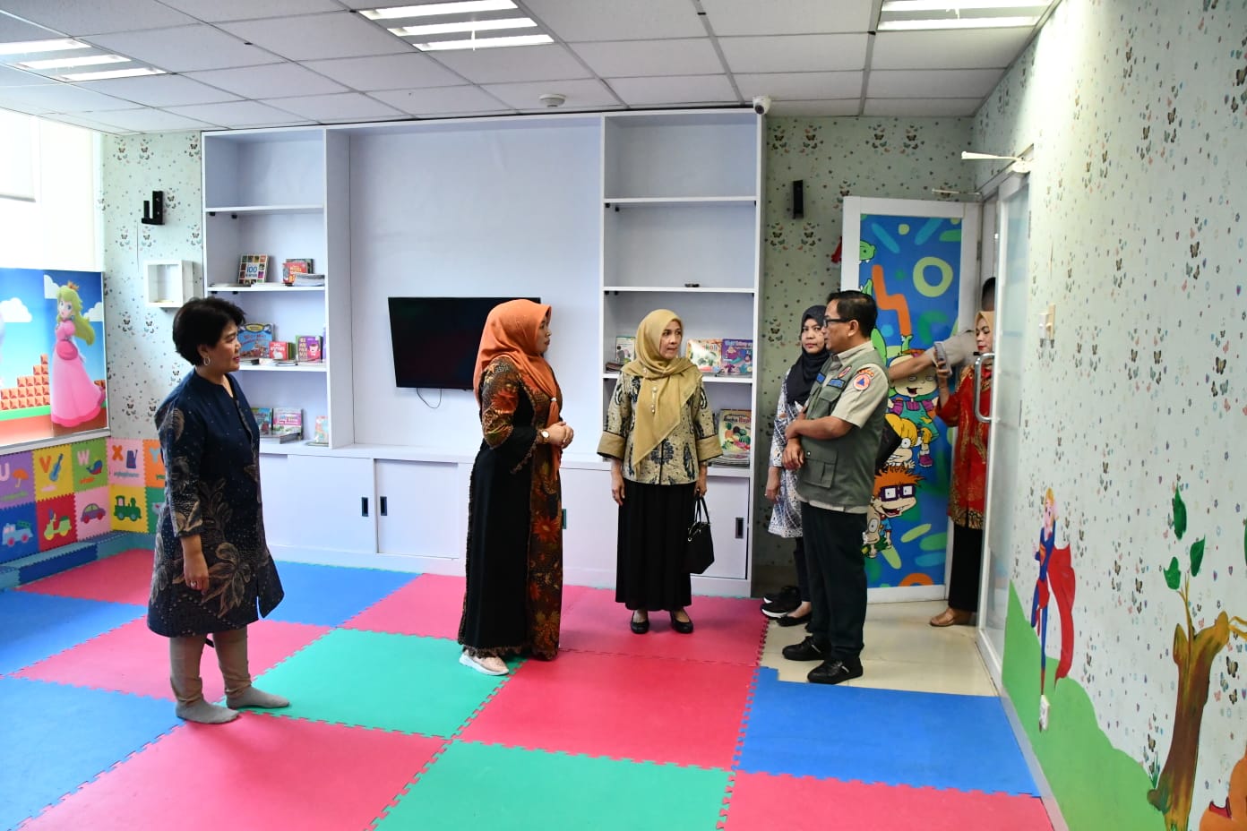 Plt Sekretaris Utama BNPB Rustian (rompi hijau) dan Ketua DWP BNPB Uke Suharyanto (baju hitam dengan kerudung orange) meninjau area Day Care Cinta Agnimaya yang bertempat di Lantai 2 Gedung Graha BNPB Jakarta, pada Kamis (8/6). 